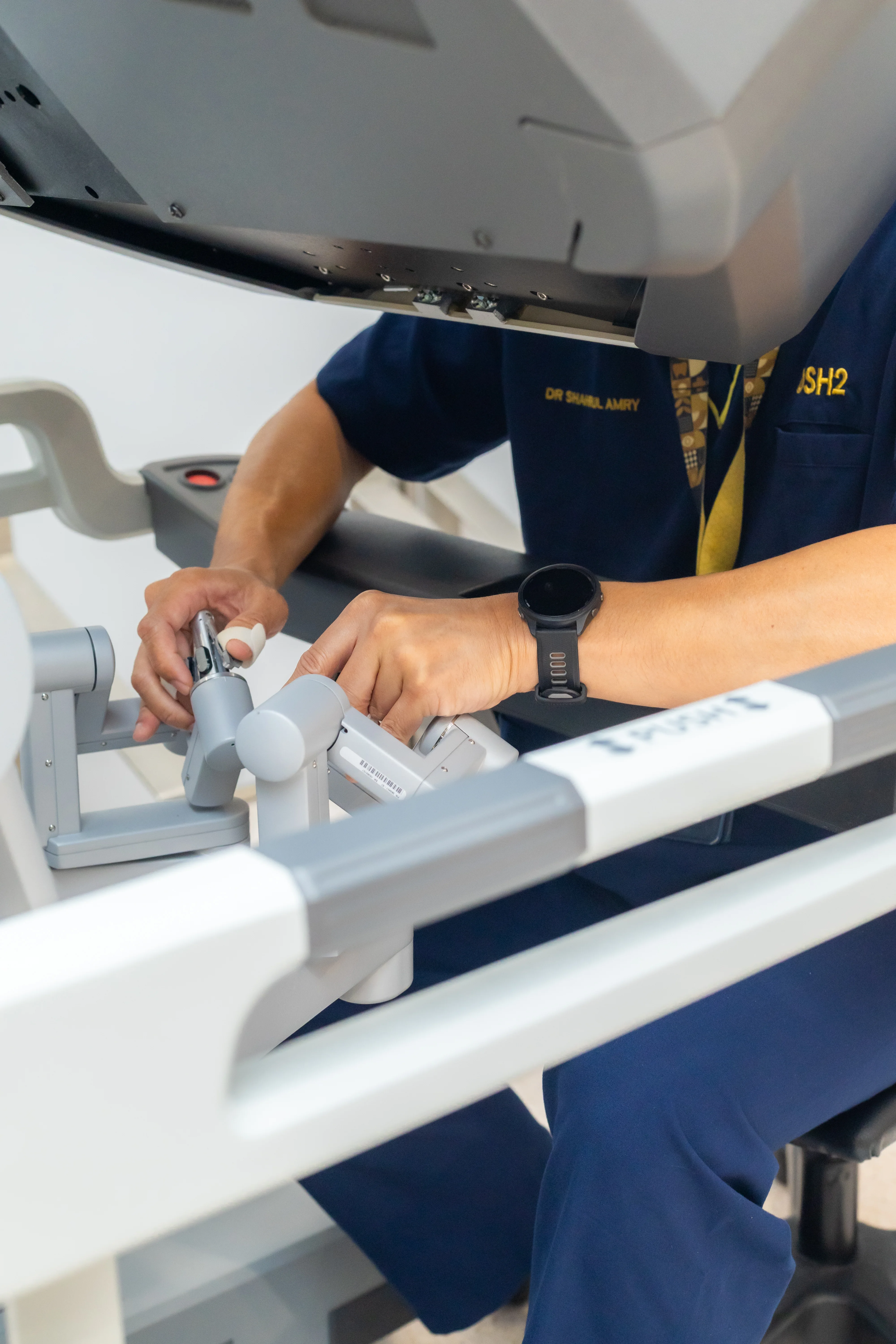 Close-up of Prof. Dr. Shahrul Amry Hashim's hands on the Da Vinci robotic surgery controls at KPJ DSH2