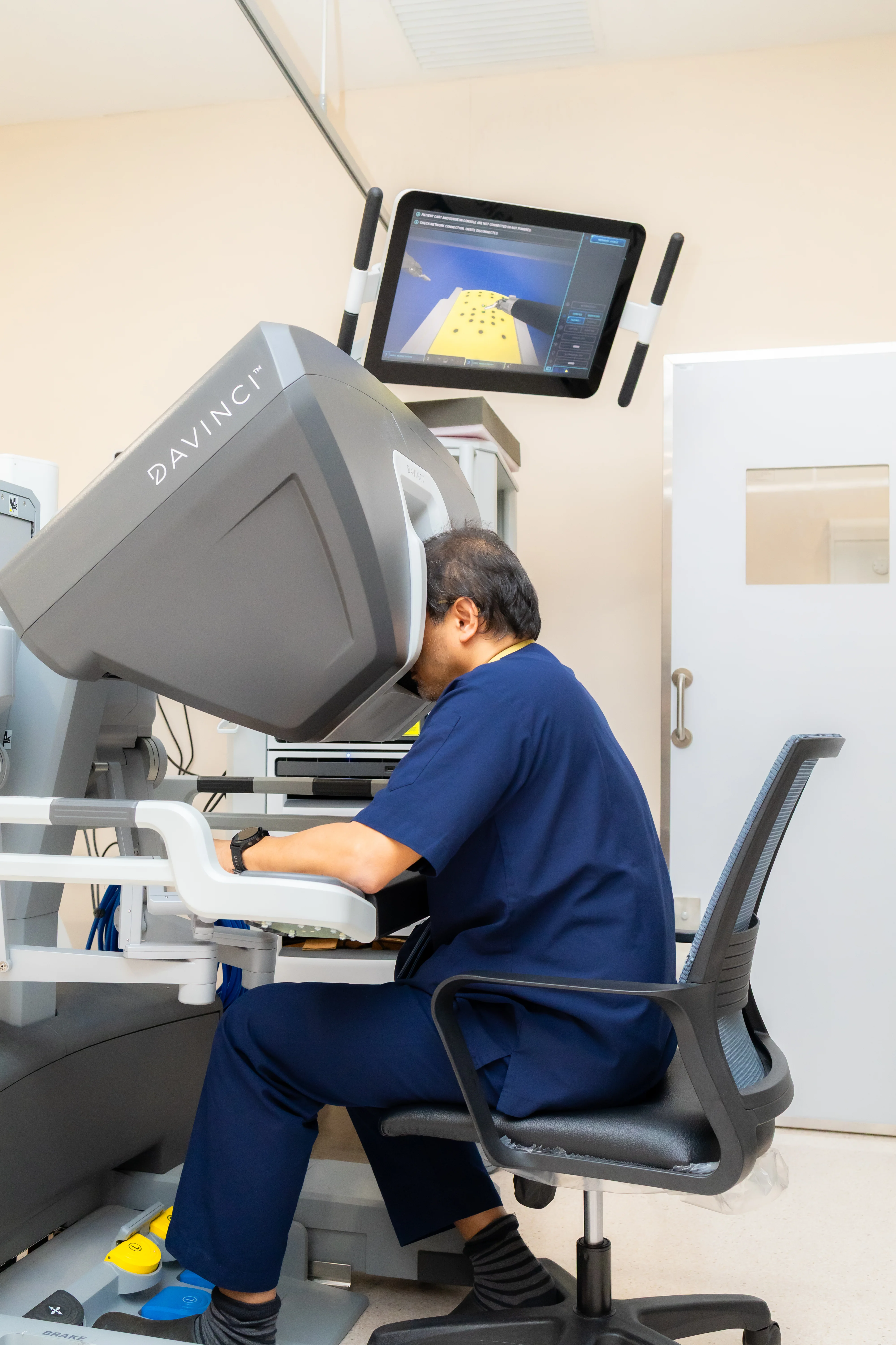 Prof. Dr. Shahrul Amry Hashim standing beside the Da Vinci robotic surgical system at KPJ DSH2